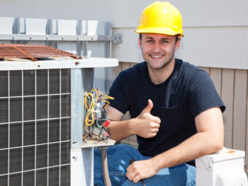 HVAC technician performing maintenance with thumbs up