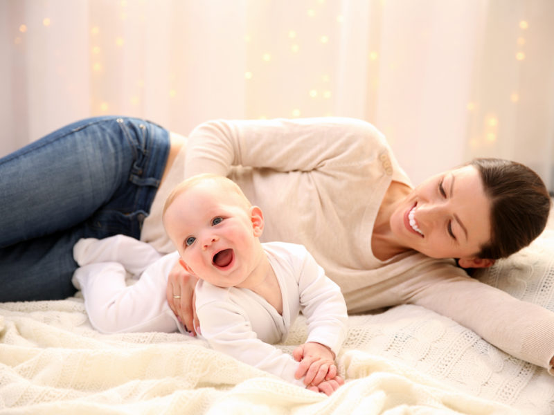 Woman and Baby on bed lauging